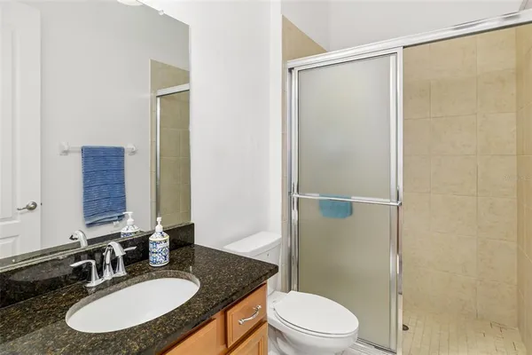 a bathroom with a granite countertop sink toilet and shower
