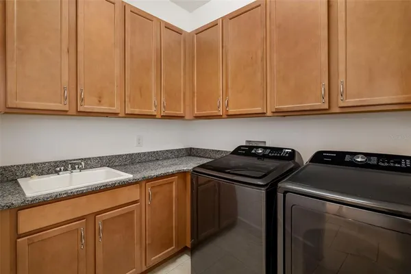 a kitchen with granite countertop a sink stove and cabinets