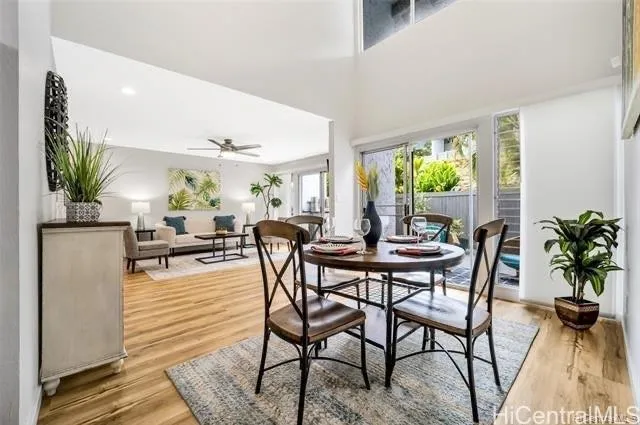 a dining room with furniture a floor to ceiling window and potted plants