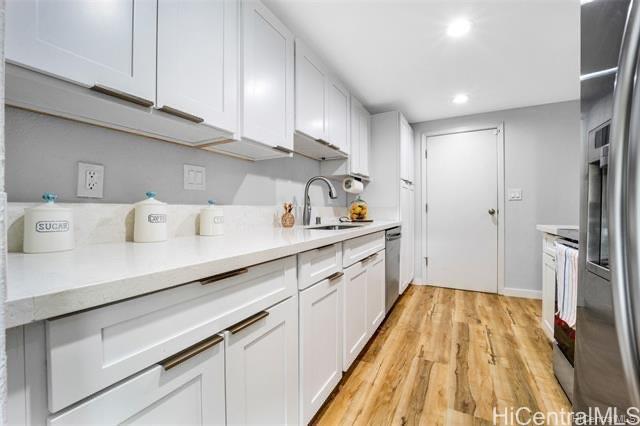 47-261 Hui Iwa Street, Unit 64 Kaneohe, HI 96744 - Photo 8 of 21 a kitchen with cabinets and wooden floor
