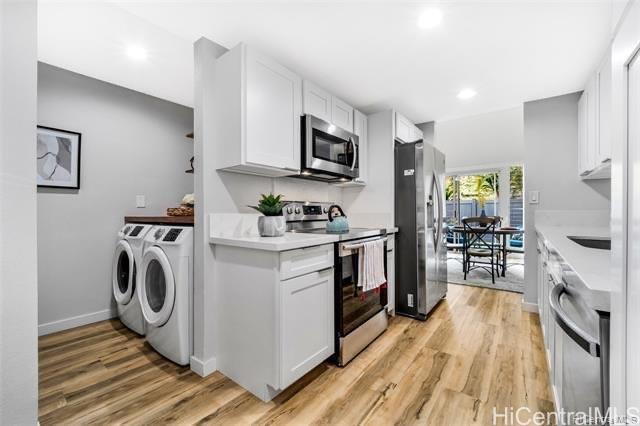 47-261 Hui Iwa Street, Unit 64 Kaneohe, HI 96744 - Photo 9 of 21 a kitchen with granite countertop a stove top oven a sink a counter space and cabinets