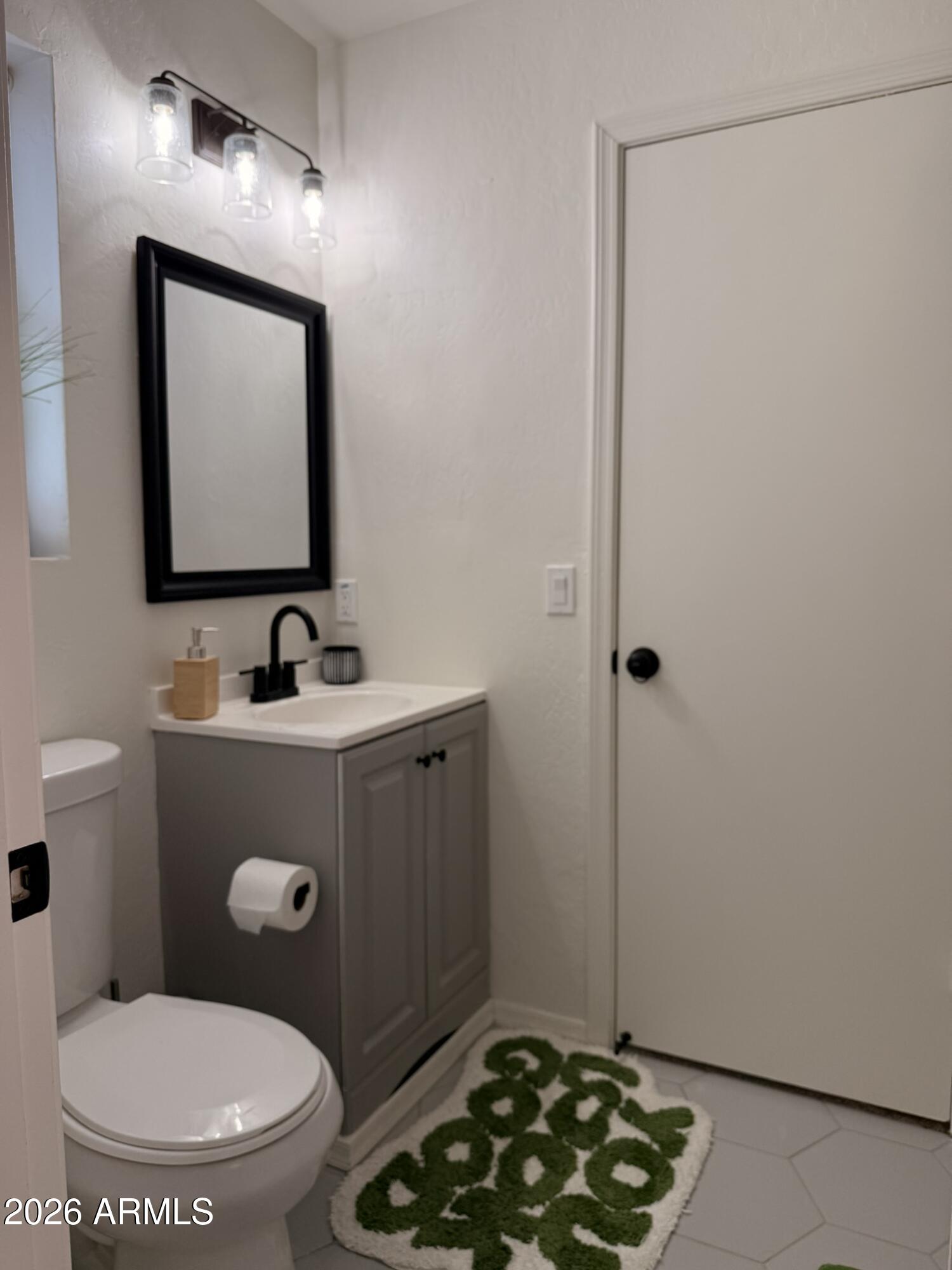 2554 West Kathleen Road Phoenix, AZ 85023 - Photo 17 of 22 a bathroom with a toilet a sink a vanity and mirror