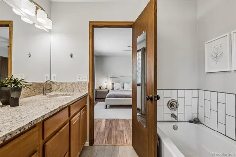 a en suite bathroom with a granite countertop tub and a sink