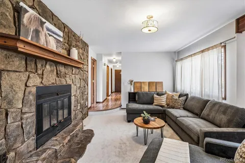 a living room with furniture a fireplace and a window