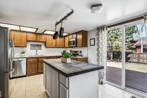 a kitchen with stainless steel appliances granite countertop wooden cabinets a sink and a stove