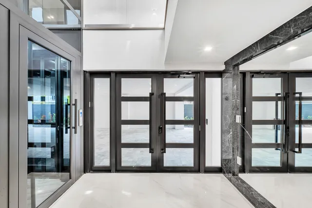 a large white kitchen with a large counter top sink and stainless steel appliances