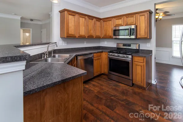 a kitchen with stainless steel appliances granite countertop a sink stove and microwave