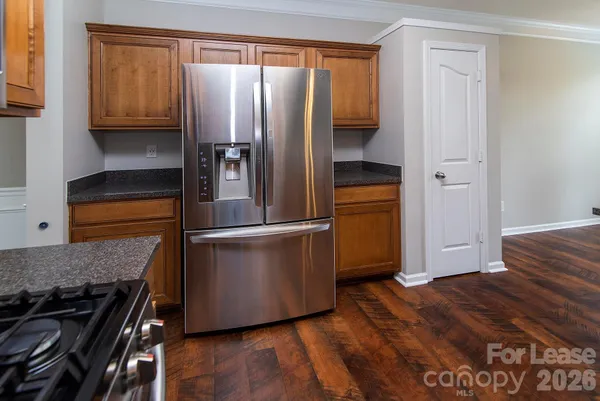 a kitchen with stainless steel appliances granite countertop a refrigerator and a stove
