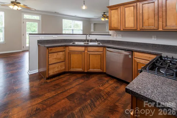 a kitchen with granite countertop a sink stove and cabinets