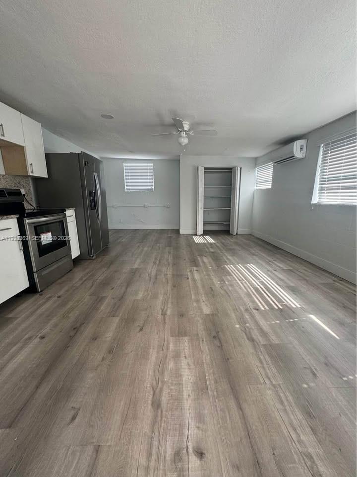 a view of a livingroom with wooden floor and a window