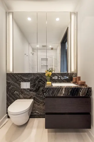 a bathroom with a large mirror and toilet