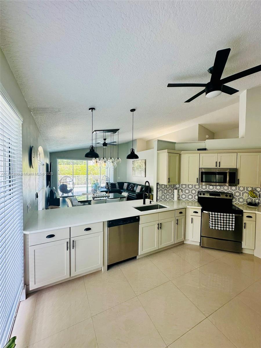 3961 Antigua Point Drive Boca Raton, FL 33487 - Photo 18 of 65 a kitchen with stainless steel appliances granite countertop a sink and cabinets