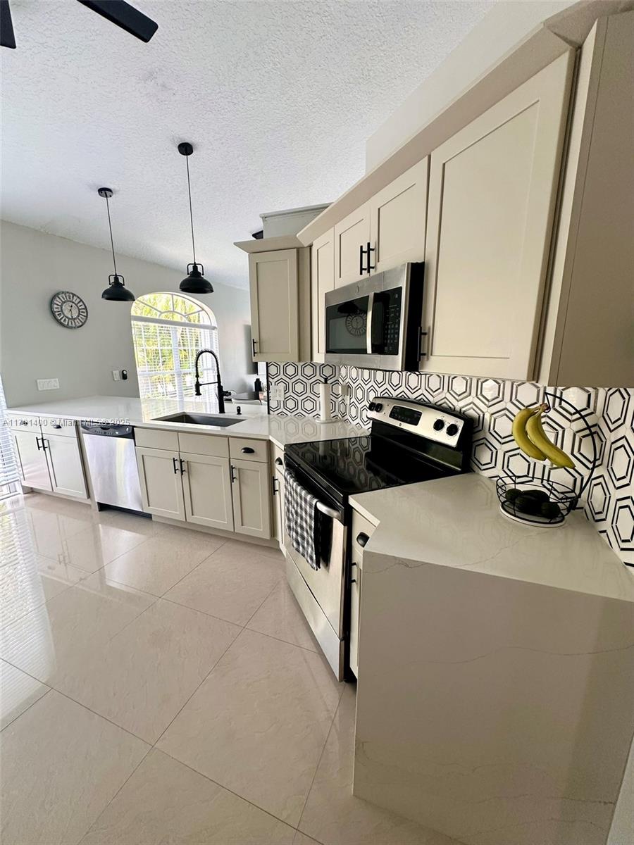 3961 Antigua Point Drive Boca Raton, FL 33487 - Photo 20 of 65 a kitchen with stainless steel appliances granite countertop a sink a stove and a refrigerator