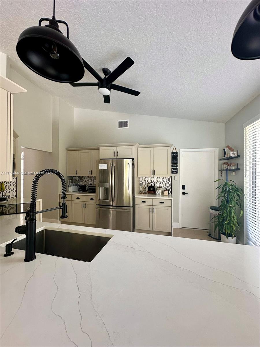 3961 Antigua Point Drive Boca Raton, FL 33487 - Photo 21 of 65 a kitchen with stainless steel appliances kitchen island a white counter top and stove