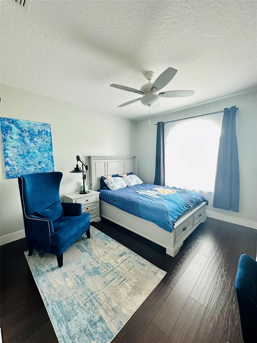 3961 Antigua Point Drive Boca Raton, FL 33487 - Photo 25 of 65 a bedroom with a bed a couch and a dresser with wooden floor