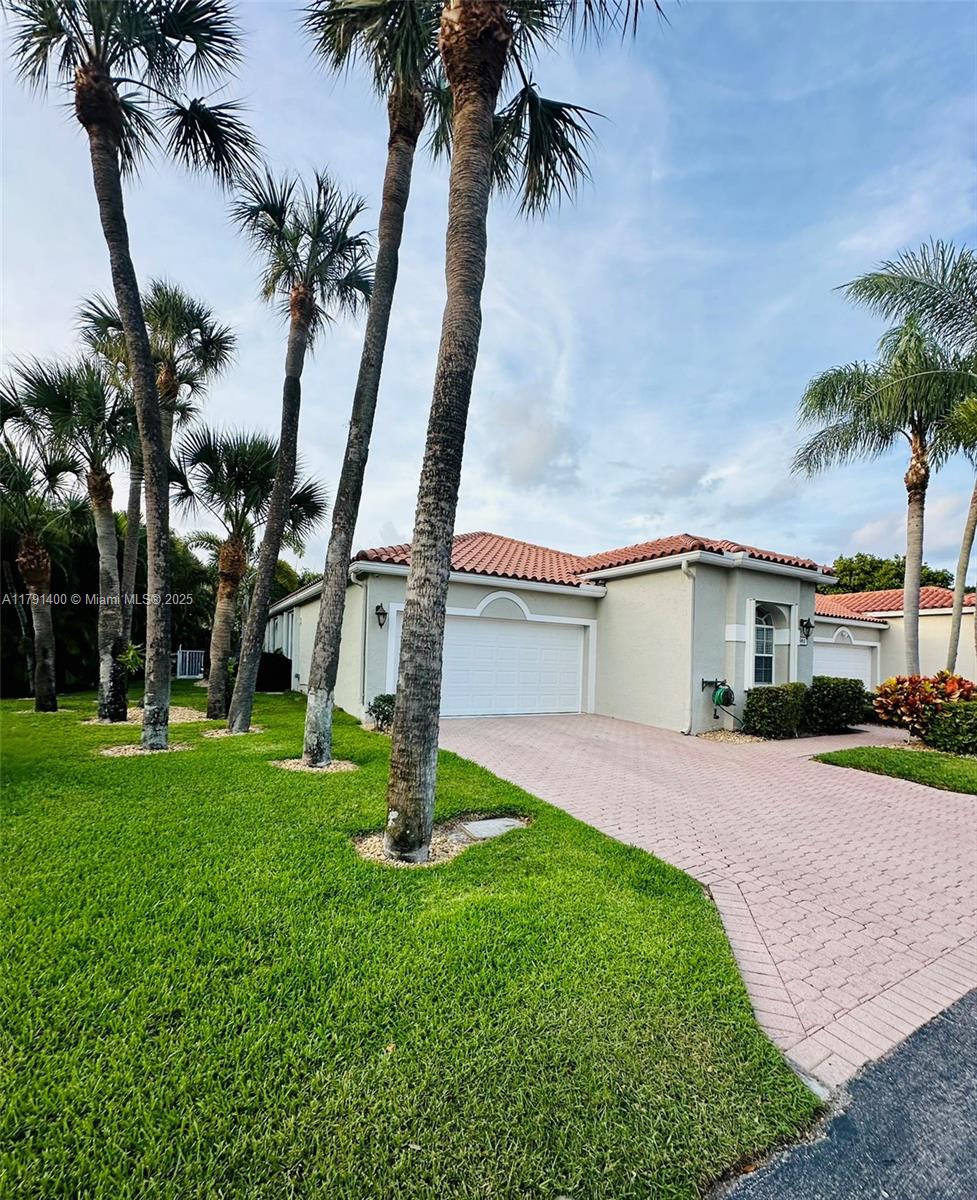 3961 Antigua Point Drive Boca Raton, FL 33487 - Photo 43 of 65 a front view of a house with a garden and yard