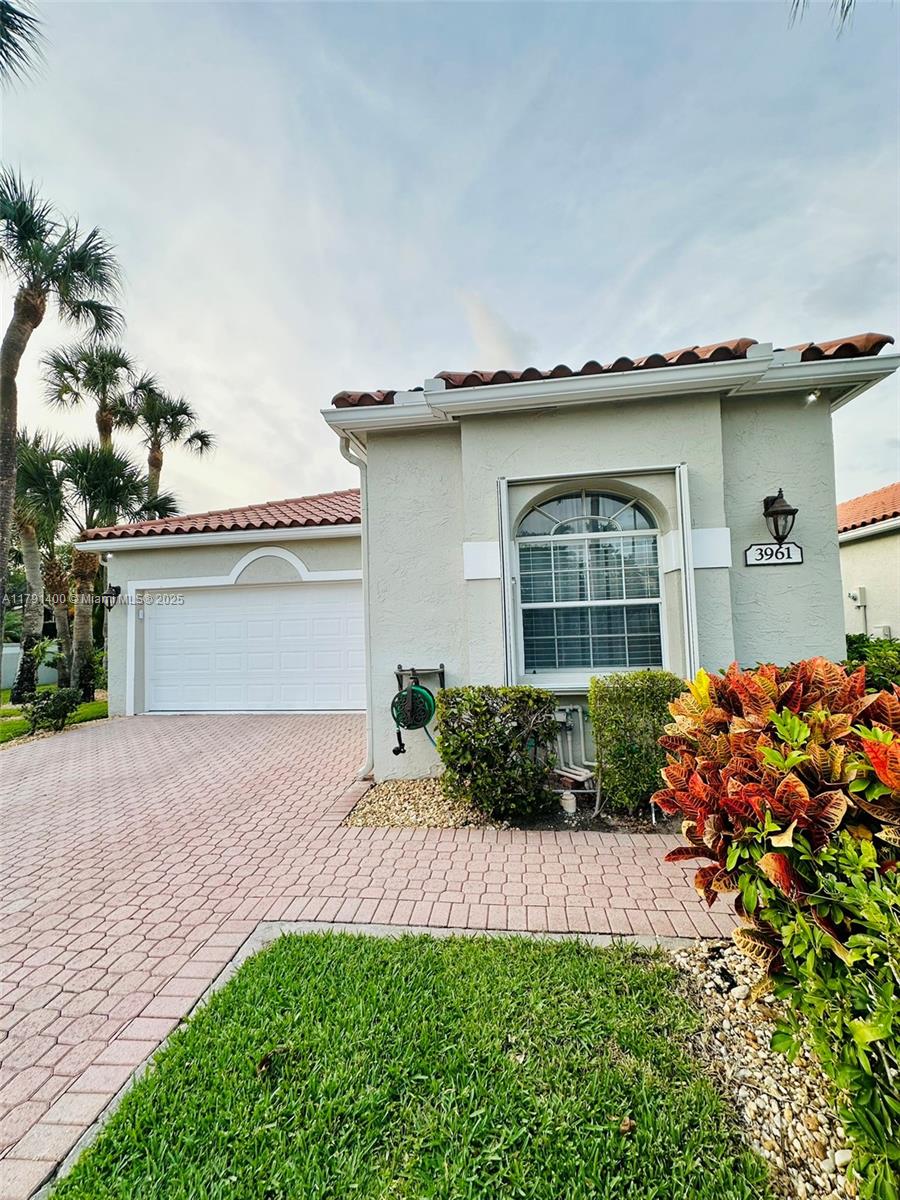 3961 Antigua Point Drive Boca Raton, FL 33487 - Photo 46 of 65 a front view of a house with a yard and garage