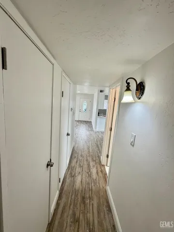 a view of a hallway with wooden floor and staircase