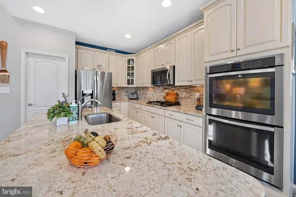 a living room with furniture kitchen view and a large window