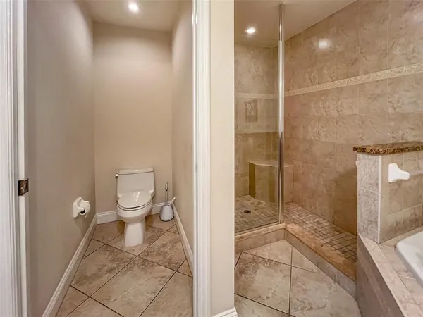 a bathroom with a toilet and a shower