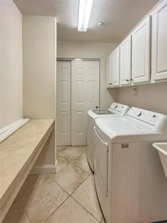 a utility room with cabinets washer and dryer