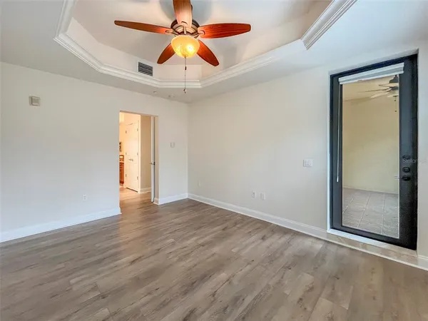 a view of an empty room with window and wooden floor