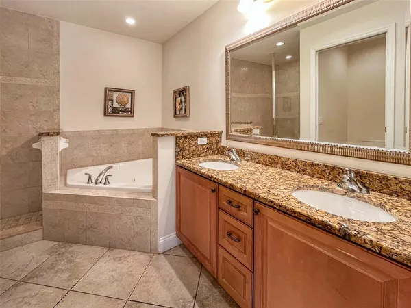 a bathroom with a granite countertop bathtub sink and mirror