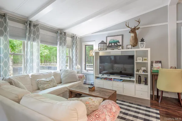 a living room with furniture a flat screen tv and a fireplace