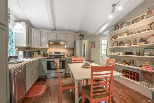 a kitchen with granite countertop lots of wooden furniture and stainless steel appliances
