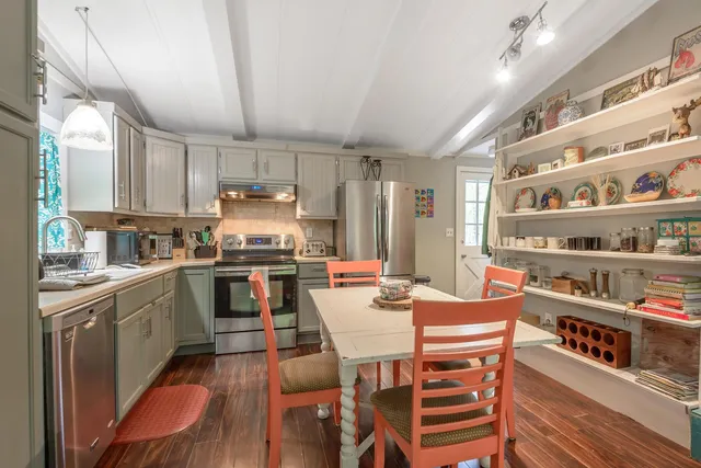 a kitchen with granite countertop lots of wooden furniture and stainless steel appliances
