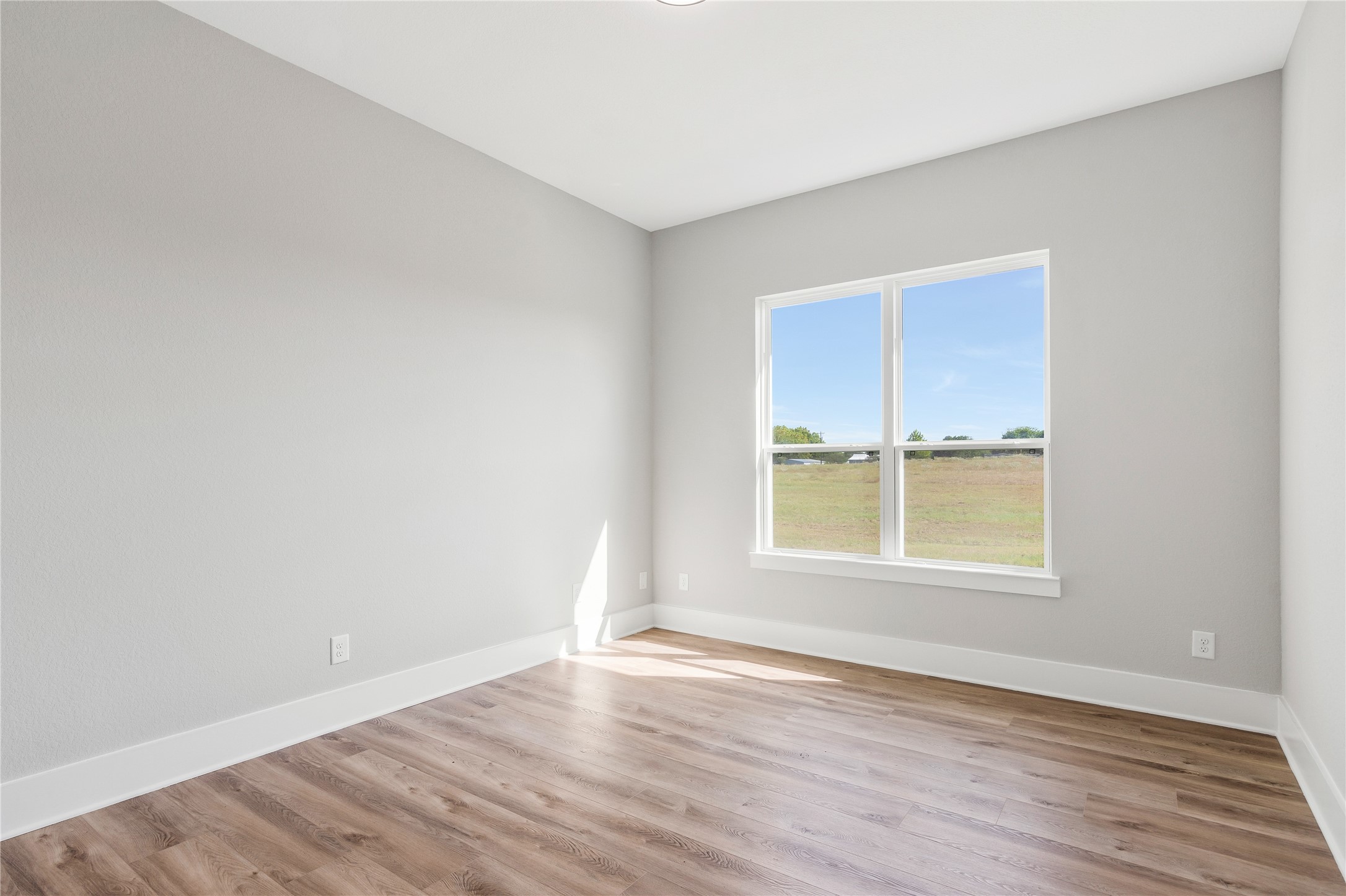 1404 Bluebonnet Ridge Drive Chappell Hill, TX 77426 - Photo 33 of 49 Bright and airy bedroom with serene views and sleek flooring—perfect for relaxation.