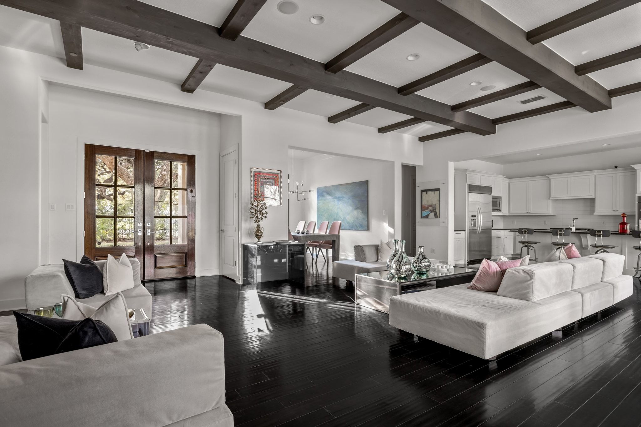 4720 Rockcliff Road, Unit 1 Austin, TX 78746 - Photo 12 of 39 Elegant dark hardwood floors stretch across this open-concept living space, illuminated by recessed lighting and a beamed ceiling.