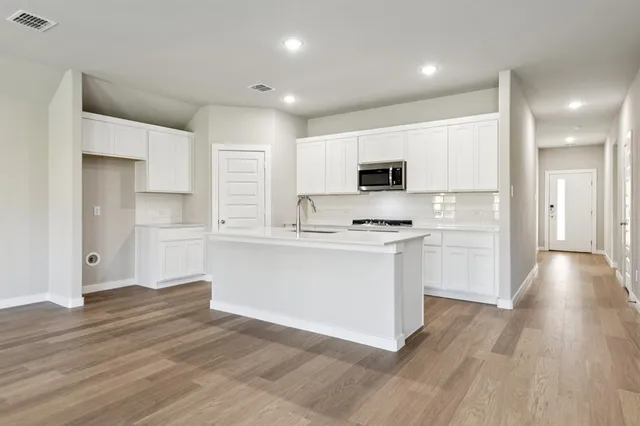 a kitchen with a refrigerator and a stove top oven