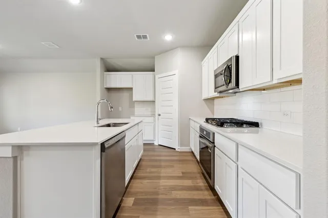 a kitchen with stainless steel appliances granite countertop a stove and a sink