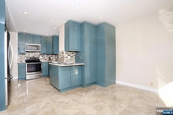 a kitchen with stainless steel appliances granite countertop a sink stove and cabinets