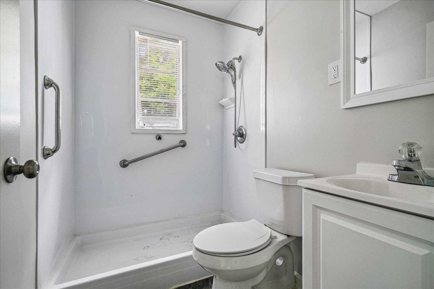 2518 Manchester Road Memphis, TN 38114 - Photo 8 of 23 Bathroom featuring a white shower with an integrated window, a white toilet, and a vanity with an integrated sink