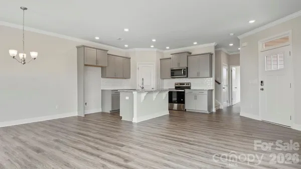 a view of kitchen view wooden floor cabinets and stainless steel appliances