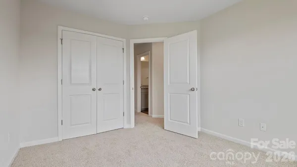 a view of an empty room with closet and a window