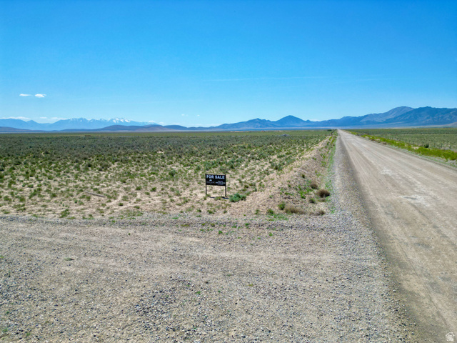 Undisclosed Address Cedar Valley, UT 84013 - Photo 1 of 1 Expansive undeveloped land featuring a gravel road, distant mountains, and open terrain