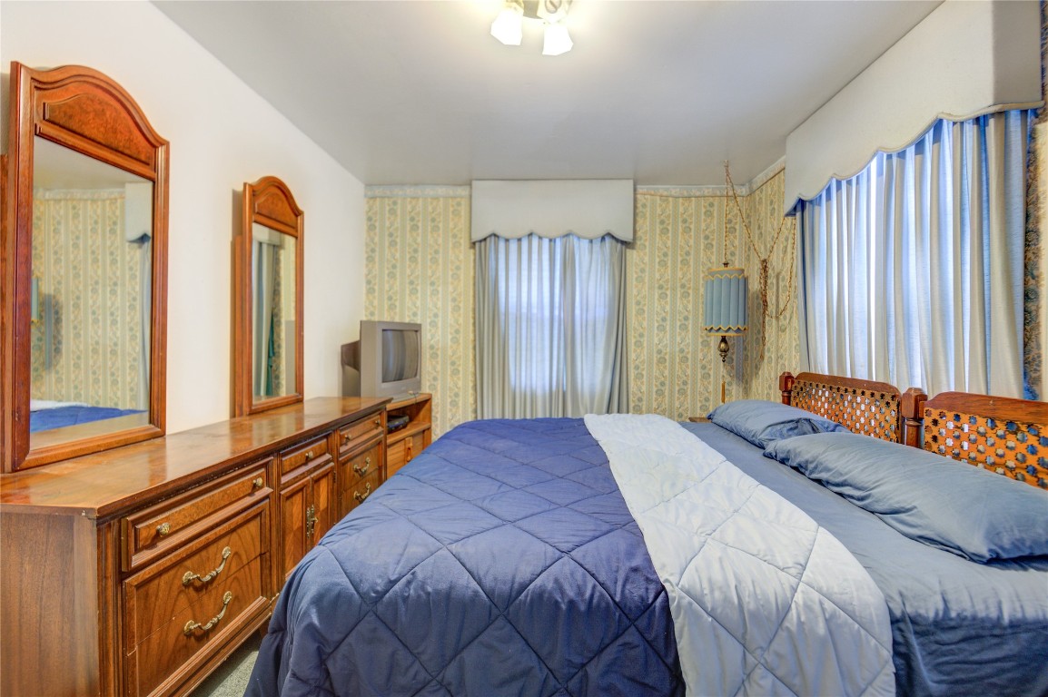 5223 Grace Point Lane Houston, TX 77048 - Photo 11 of 24 a bedroom with a bed and a large mirror next to a window