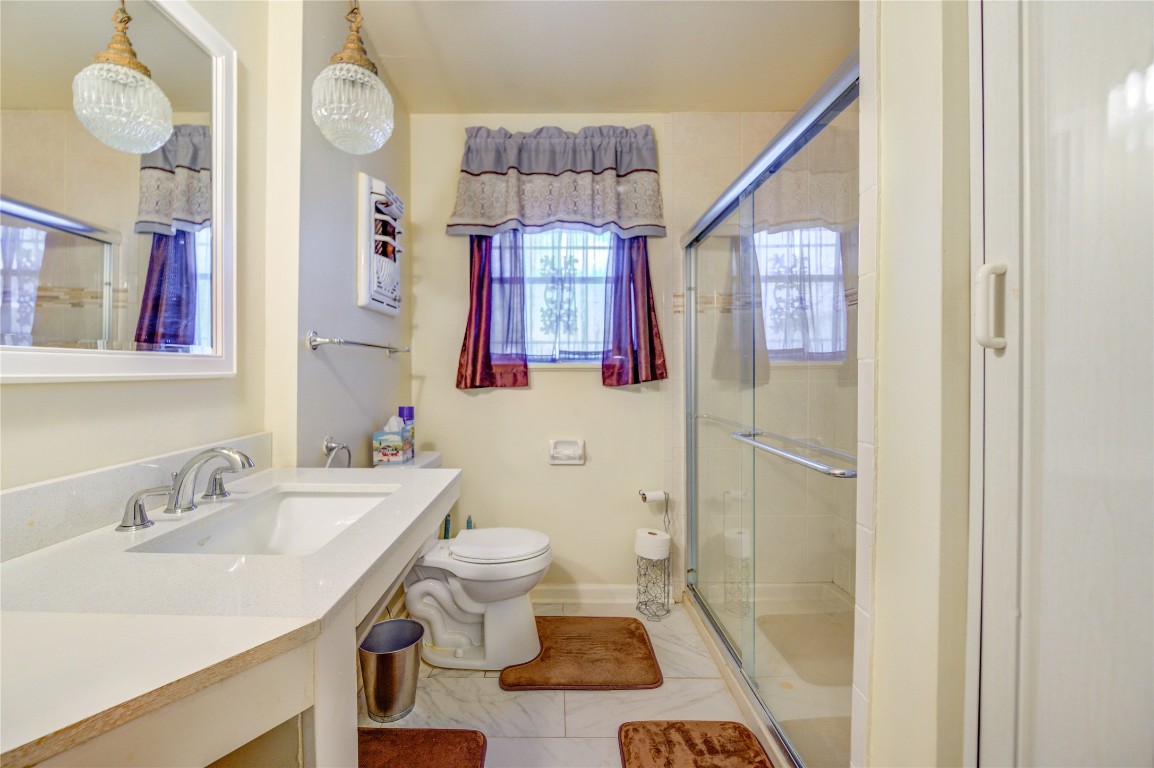 5223 Grace Point Lane Houston, TX 77048 - Photo 14 of 24 a bathroom with a sink a toilet a mirror and shower view