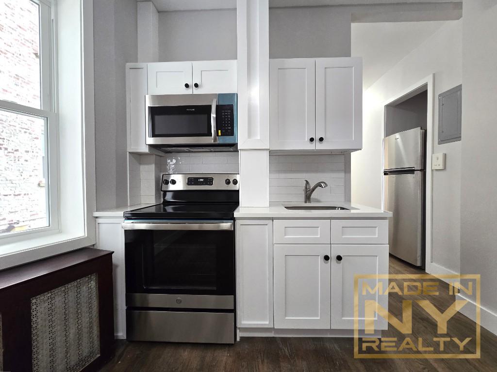 a kitchen with granite countertop a stove and a microwave oven