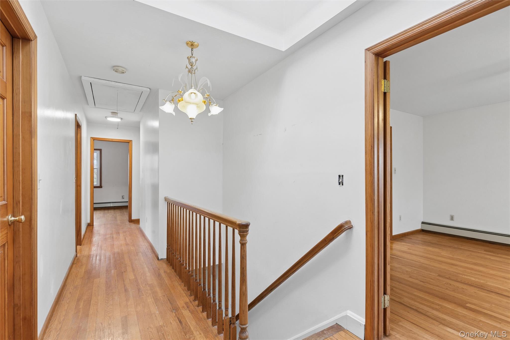 49 Overhill Road Wading River, NY 11792 - Photo 18 of 27 a view of a hallway with wooden floor and chandelier