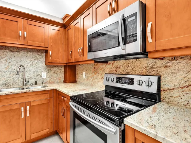 a kitchen with stainless steel appliances granite countertop a refrigerator and a sink
