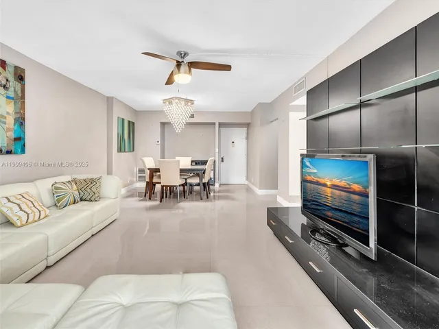 a bathroom with a toilet sink vanity granite tub and mirror