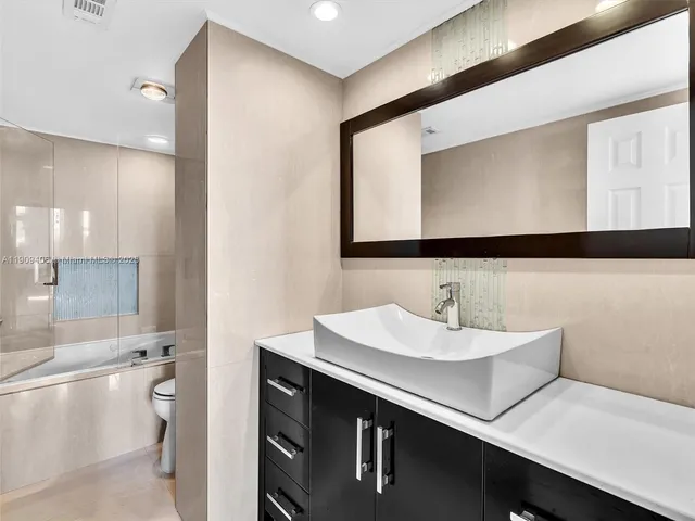 a bathroom with a toilet a sink a mirror and vanity