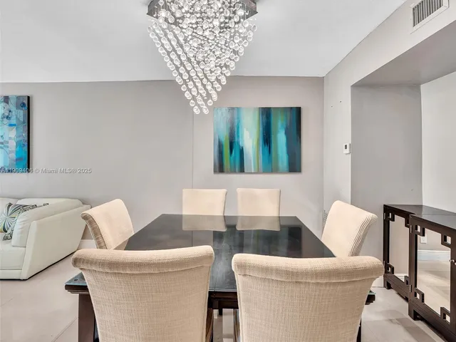 a view of a dining room with furniture and chandelier