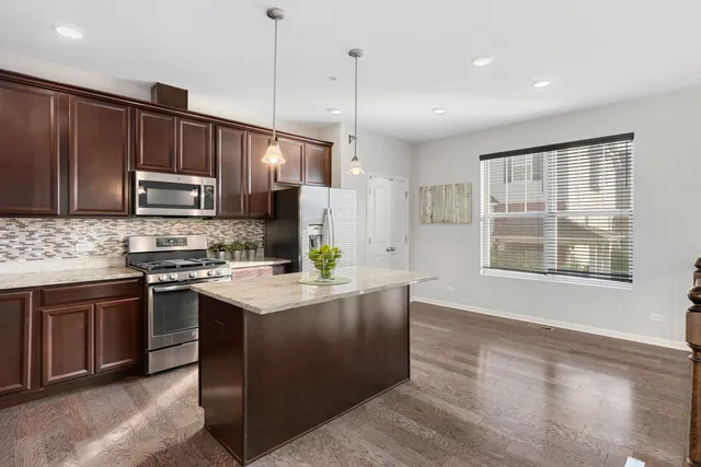 a kitchen with stainless steel appliances granite countertop wooden cabinets a stove top oven a sink and dishwasher