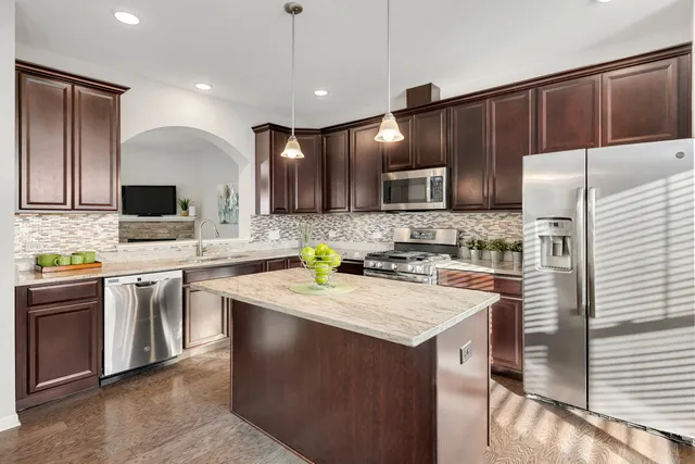 a kitchen with a sink a stove a refrigerator and cabinets