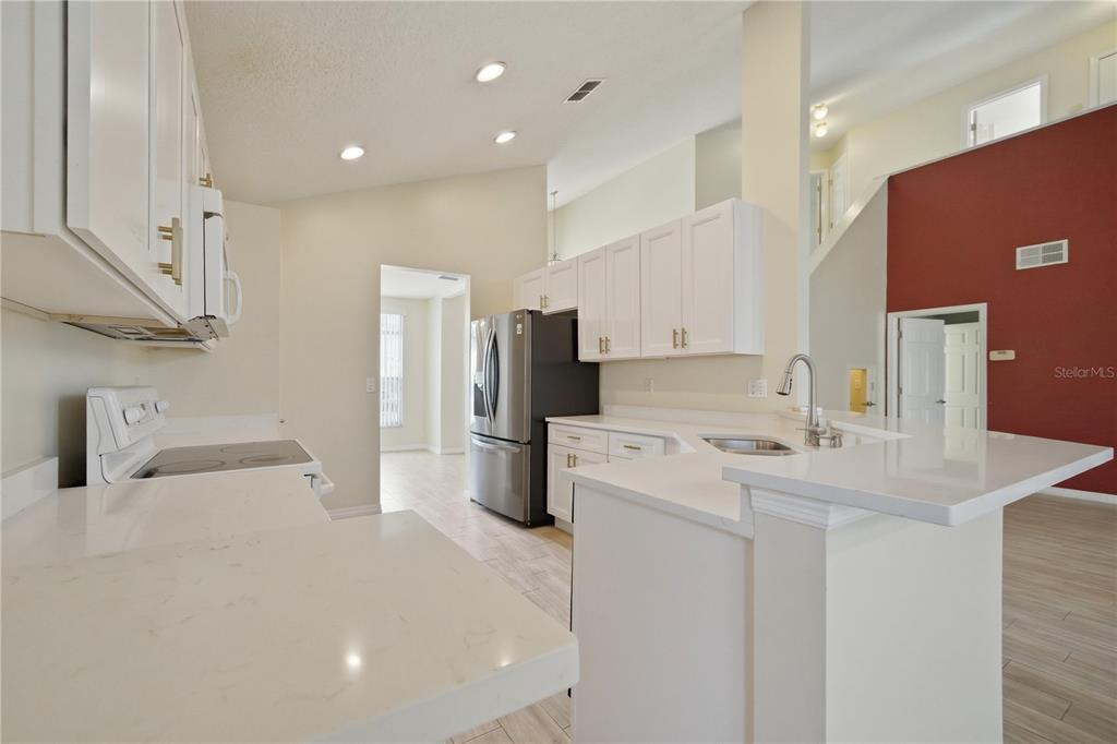 632 Blenheim Loop Winter Springs, FL 32708 - Photo 30 of 55 a kitchen with a sink a refrigerator and a stove top oven